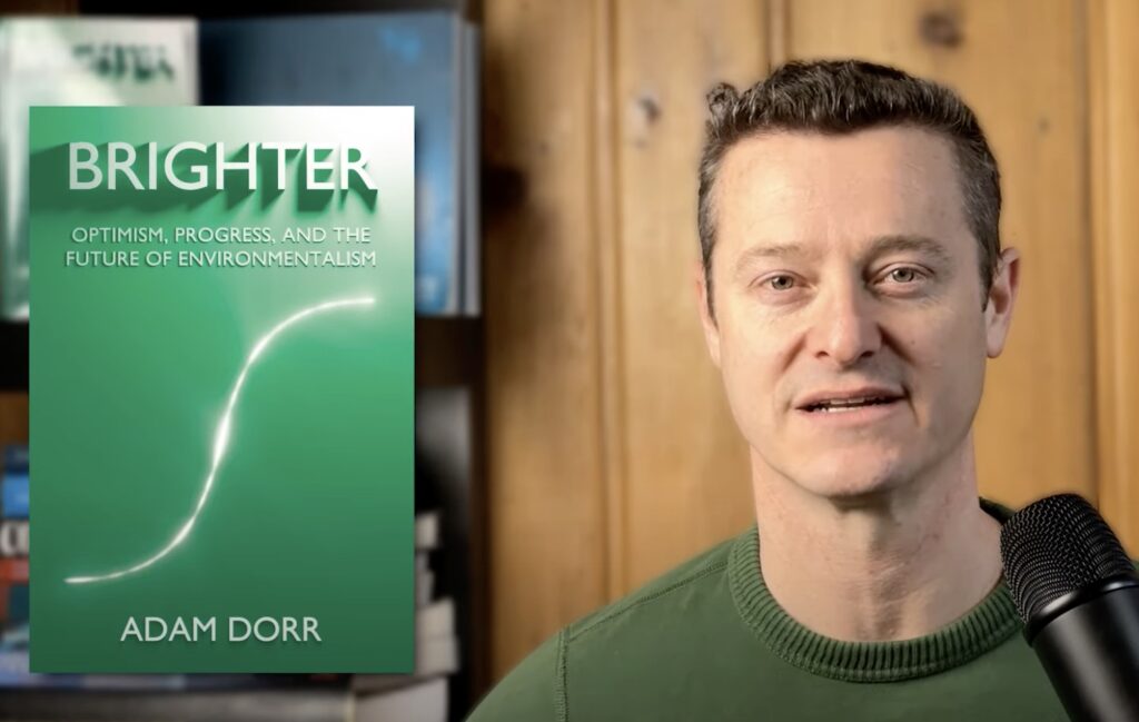 a headshot of Adam Dorr, with his book Brighter: Optimism, Progress, and the Future of Environmentalism 